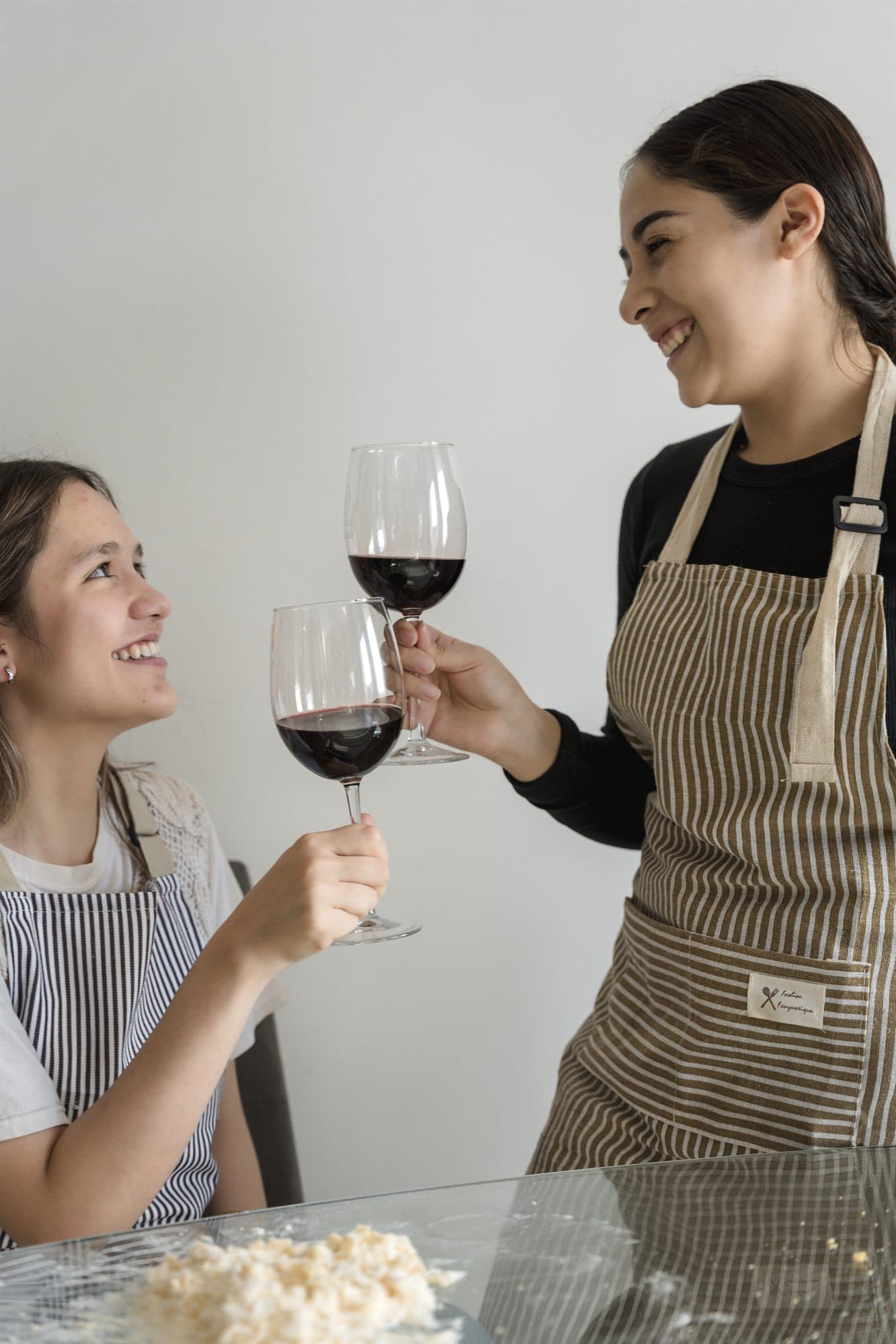 Dos mujeres riendo y brindando con vino durante una experiencia