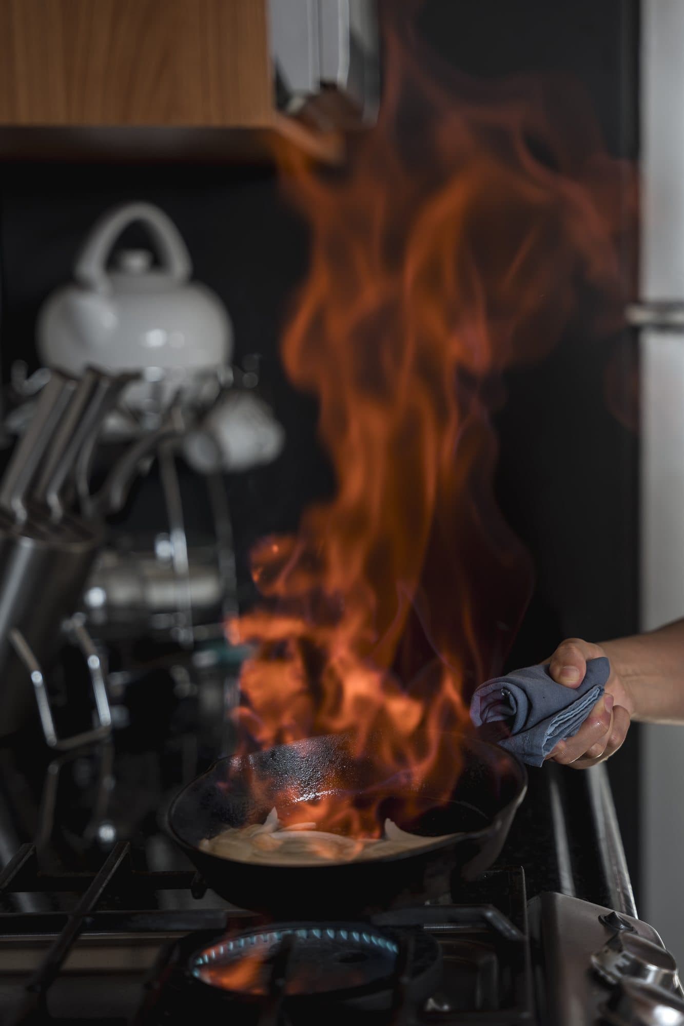 Sartén flameando al fuego durante una cena privada